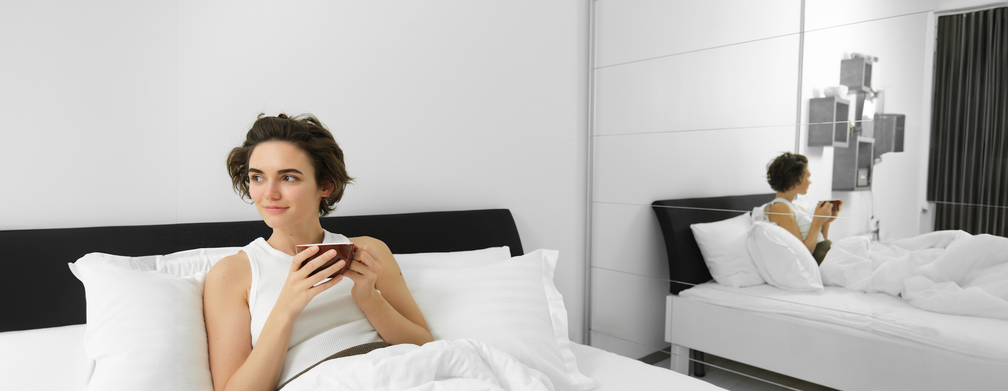 Kobieta spędzająca czas w&nbsp;pokoju hotelowym, pijąca kawę